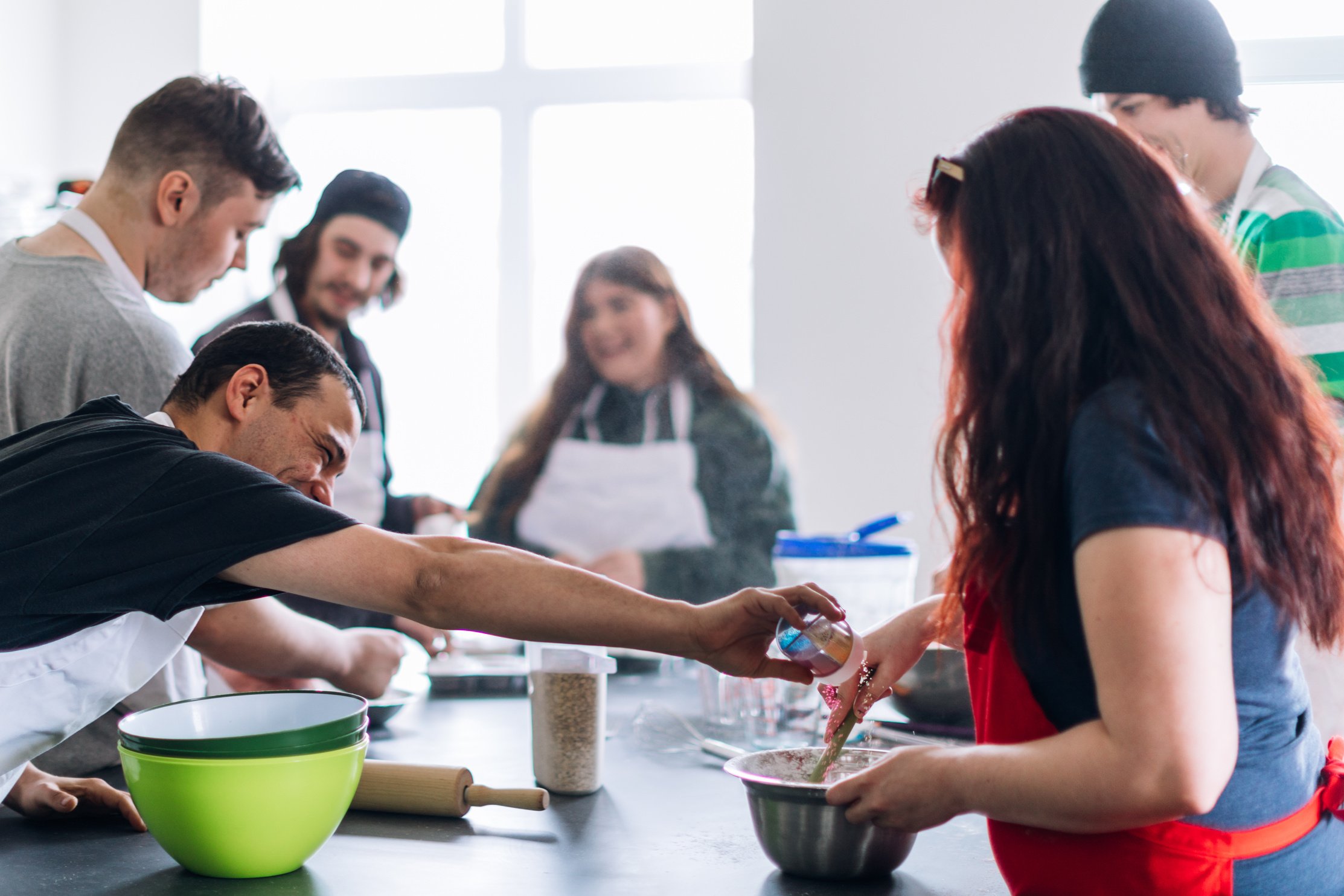 Group of people learning to cook in a community center workshop. Cooking class