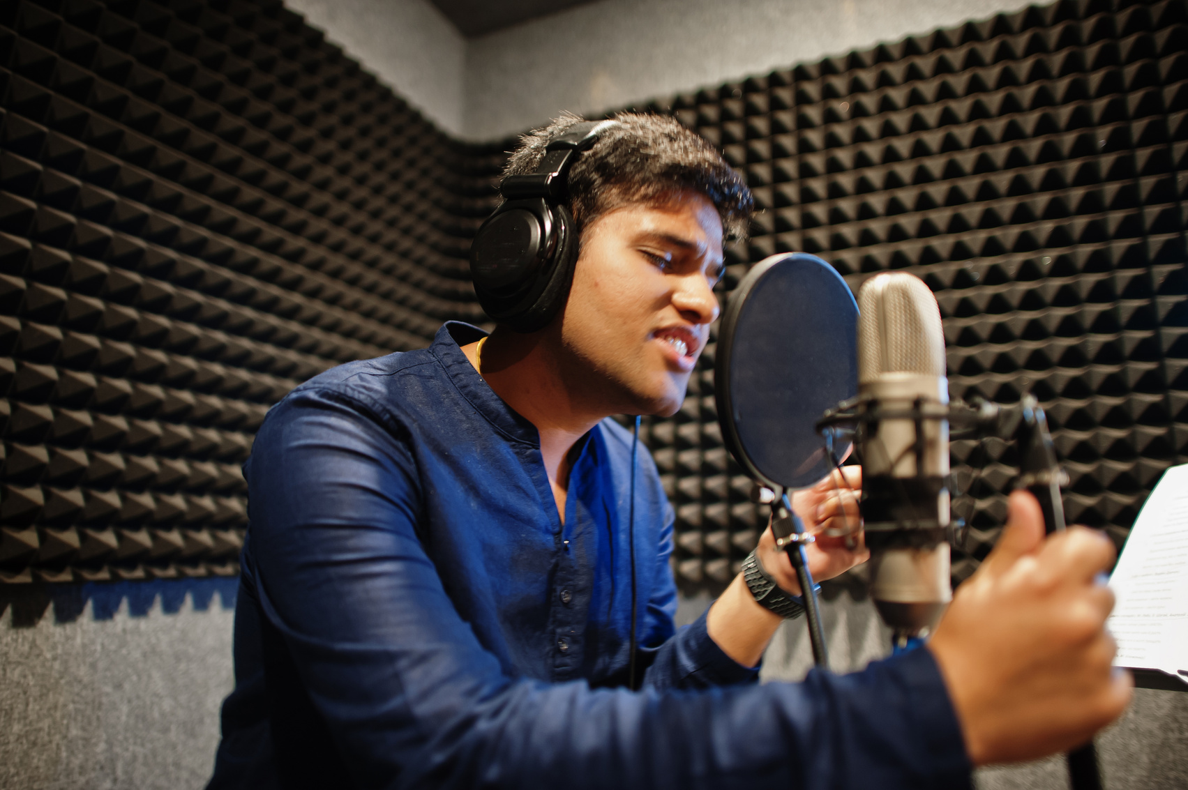 Young Asian Singer Man with Microphone Recording Song in Record